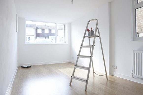 ladder with paint pot and brushes standing in empty room